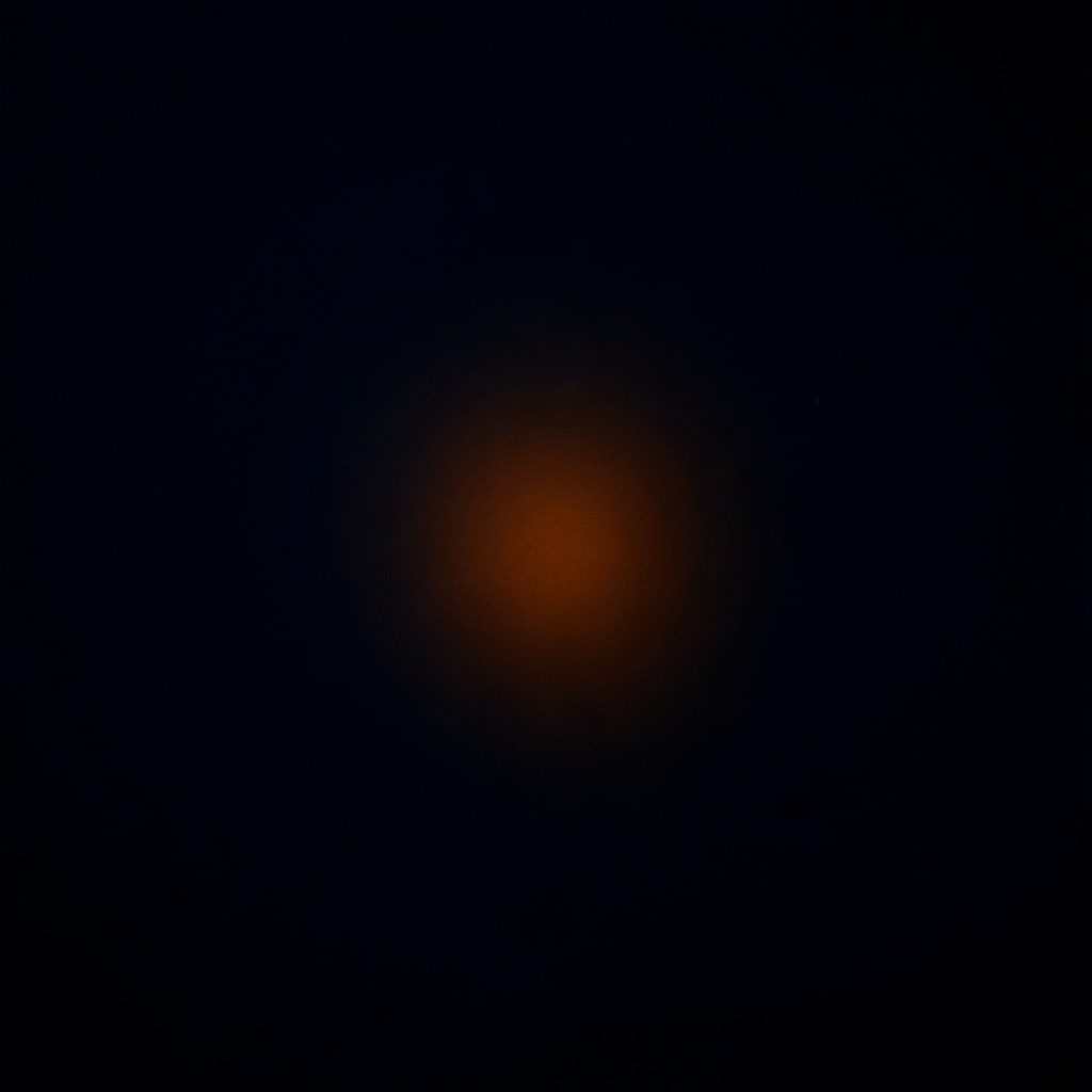 Dark photograph of a deep navy backdrop with a single warm orange highlight, dramatic and low-key